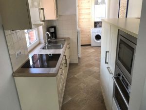 Küche mit Herd, Spüle, Backofen, Spülmaschine, Waschmaschine, Kaffeemaschine